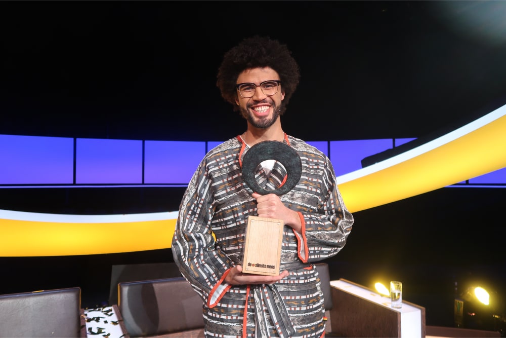 Marin Rombouts stands in the studio holding the trophy after winning the 21st season of "De Slimste Mens"