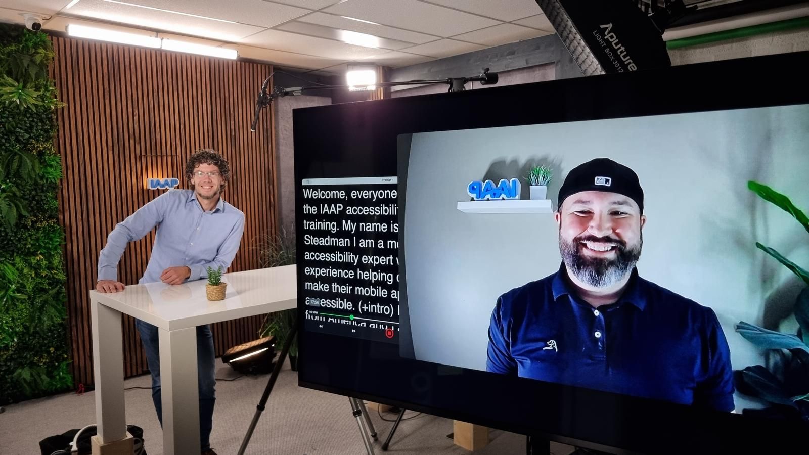 Paul in the studio and Mark on a screen, both with in the back the IAAP logo.